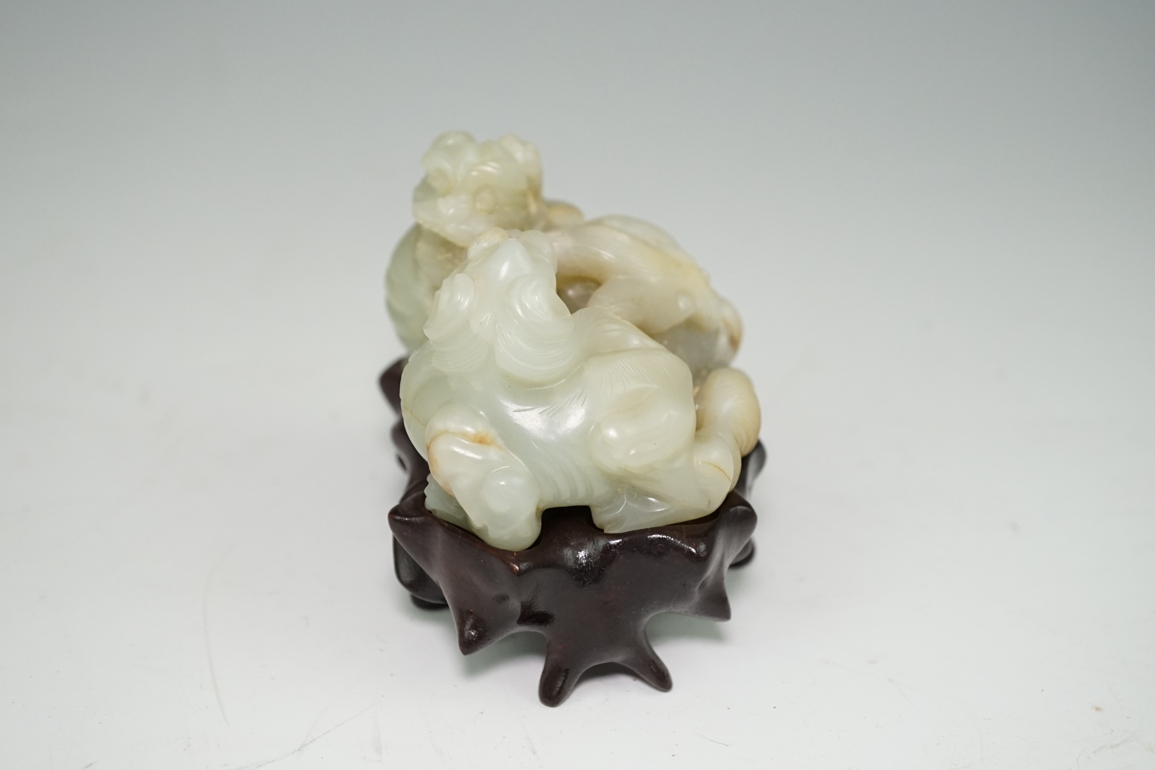 A Chinese celadon and russet jade group of two lion-dogs, 19th century